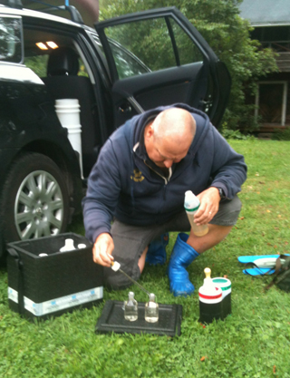 Ymp&auml;rist&ouml;n&auml;ytteenottaja Arto Muttilainen tutkii n&auml;ytteit&auml; Haapaniemess&auml; 2013